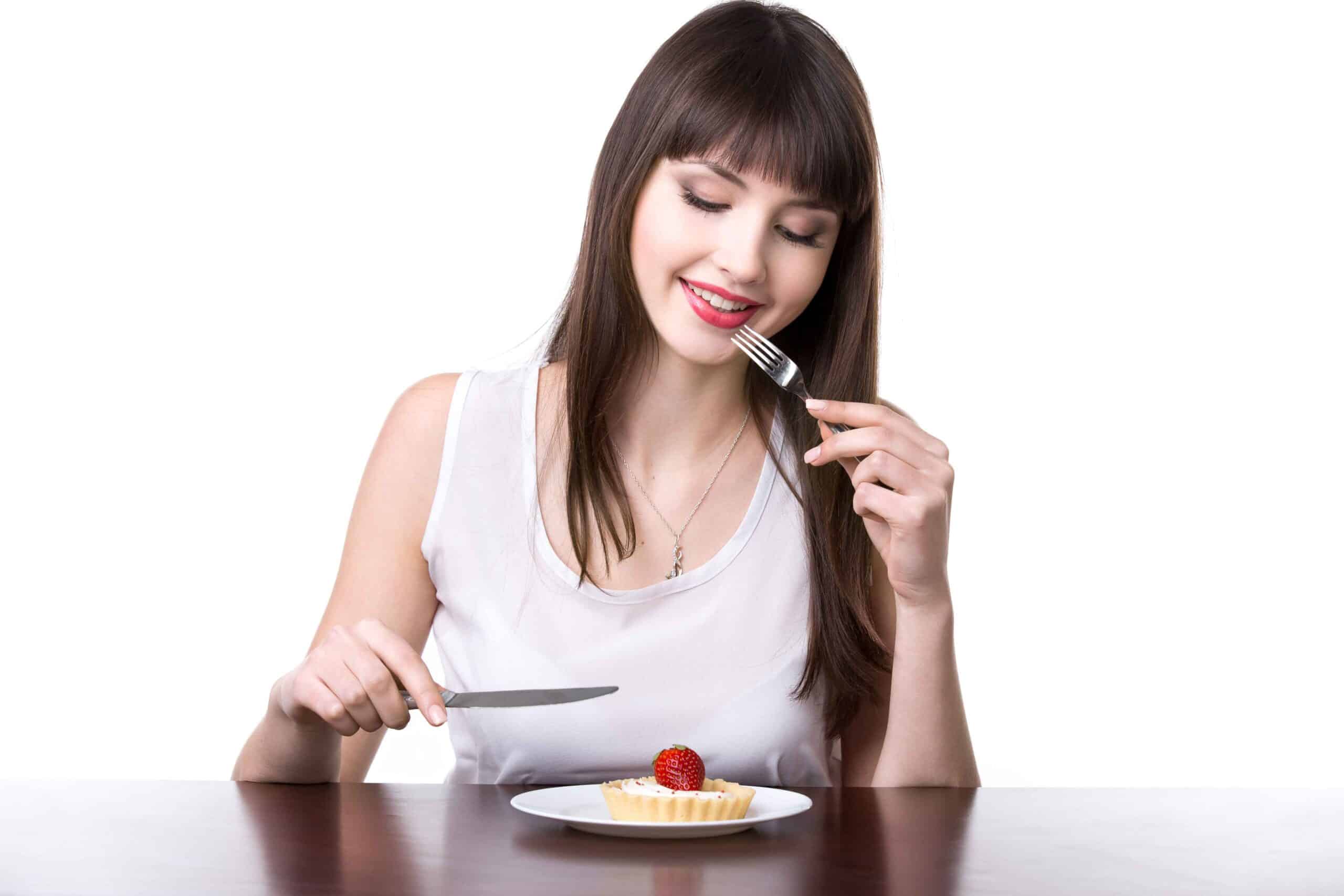 woman eating a portion of cake