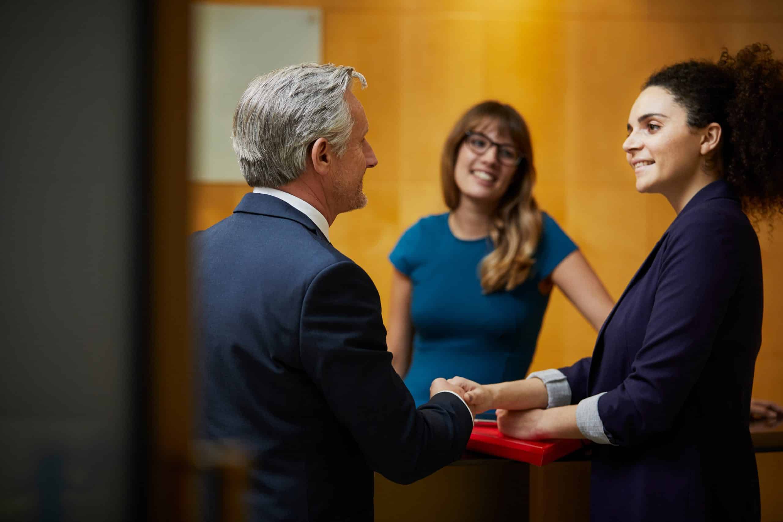 Businesswoman and man shaking hands in reception