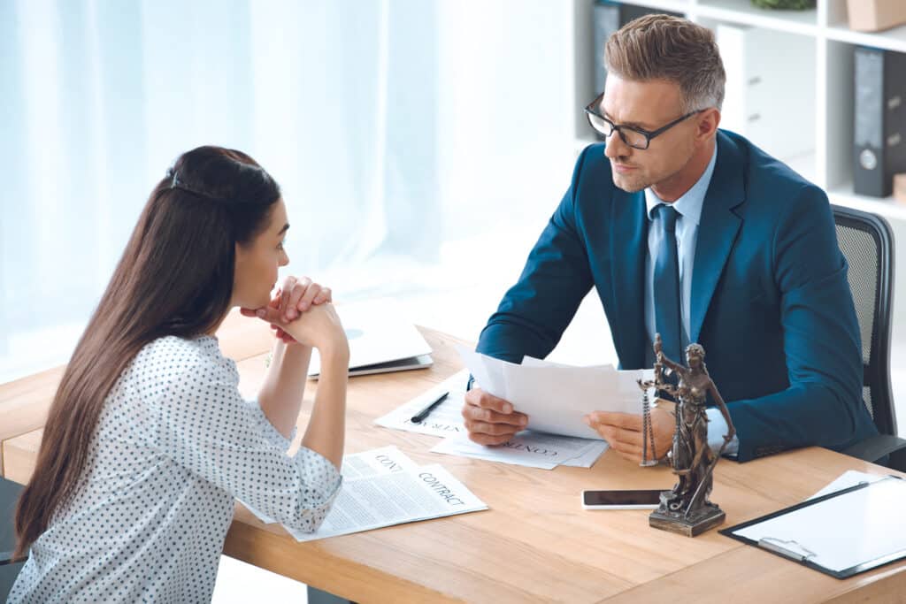 lawyer and client looking at each other while discussing contract in office, divorce settlement, asset division, asset division, non financial contribution, australian family law, divorce settlement australia, financial stability, average split, equitable outcome, marital assets, divorce process health concerns, pursuing litigation other party, four step process, investment properties, all the circumstances, credit card debt, personal loans non financial, such a division childcare responsibilities
