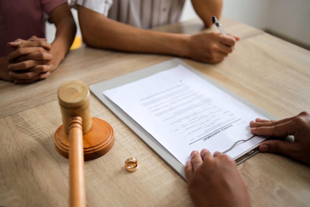 Lawyer Giving Documents to Husband and Wife Who are Going to Divorce, divorce settlement, asset division, non financial contributions, legal fees, assets divided, just and equitable outcome, australian family law, future needs