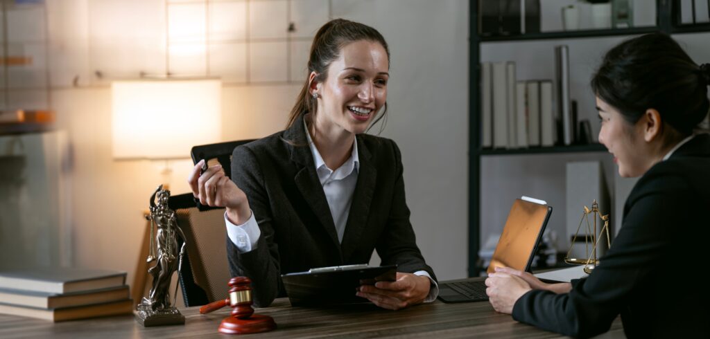 Family Lawyers Varsity Lakes Gold Coast: Expert Legal Support 4 Female lawyer meeting with a client in an office, discussing legal matters with a tablet and law symbols on the desk.