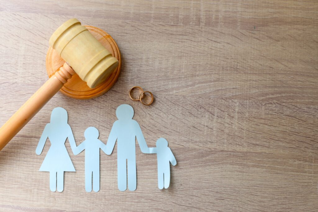 Family Lawyers Varsity Lakes Gold Coast: Expert Legal Support 2 Judge’s gavel with paper family silhouettes and wedding rings symbolising divorce, parenting, and family court decisions.