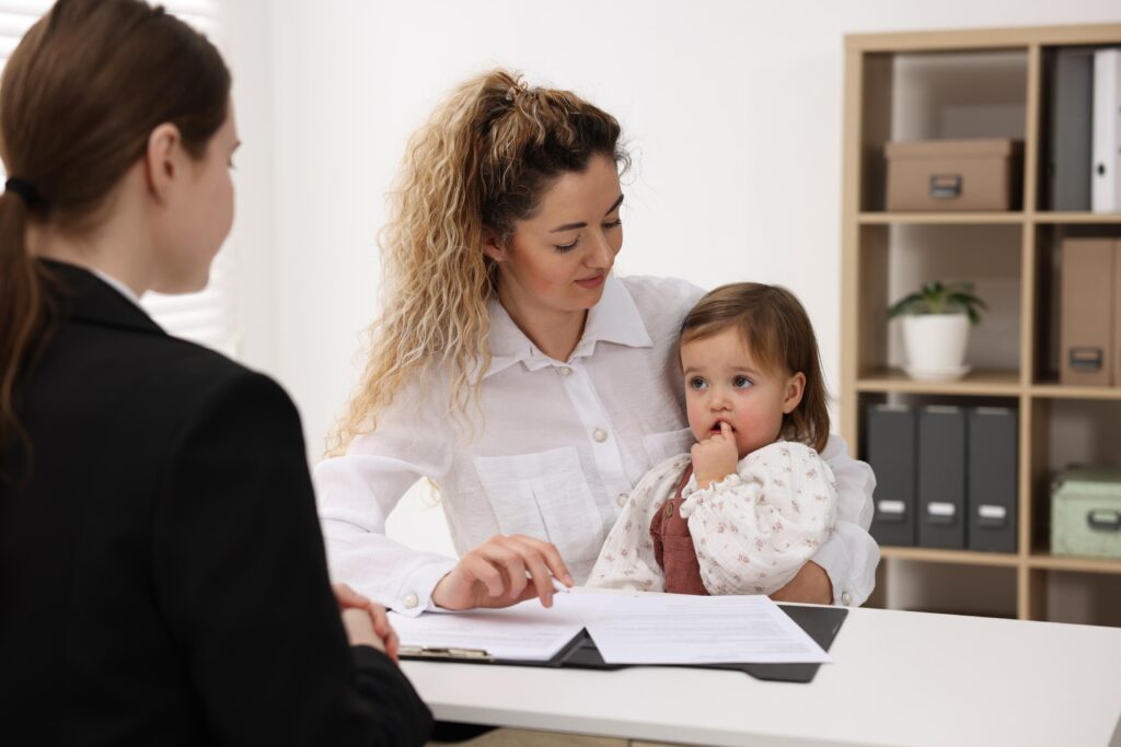 Single mother with her daughter during job interview at table in