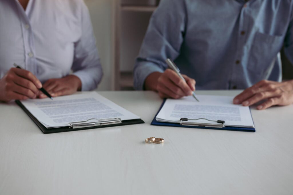 Husband and wife crate signing divorce documents at lawyer offic