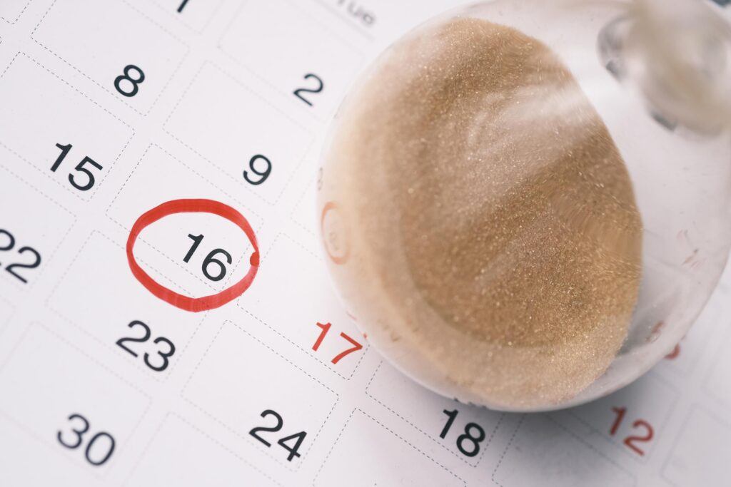 hourglass on a calendar, and flowing through the bulb of sandglass