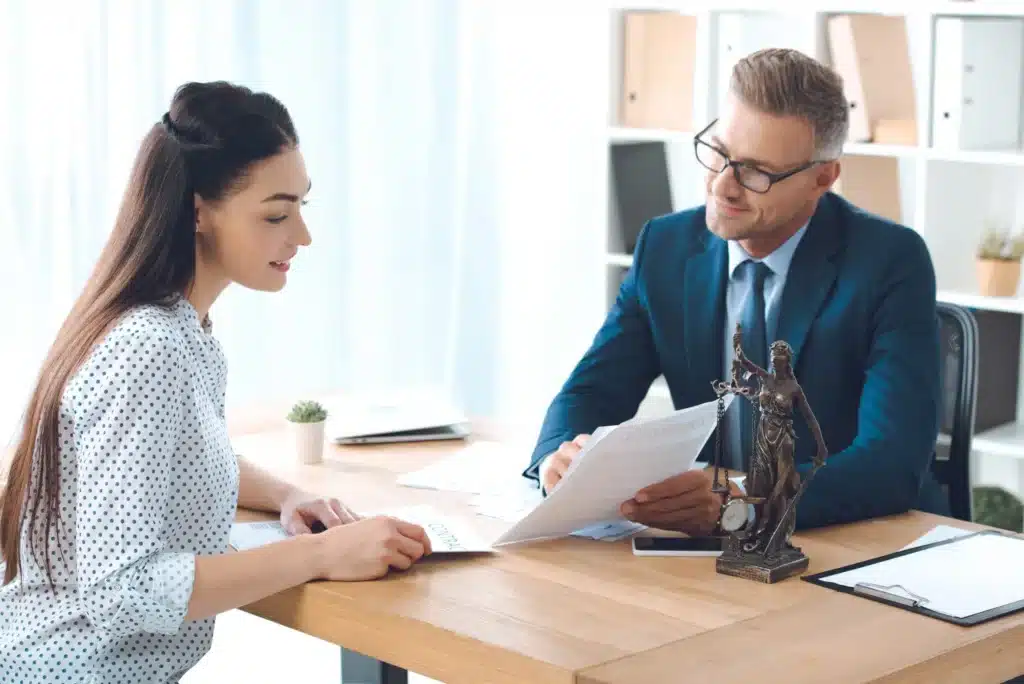smiling-lawyer-showing-papers-to-happy-client-in-office-scaled.jpg