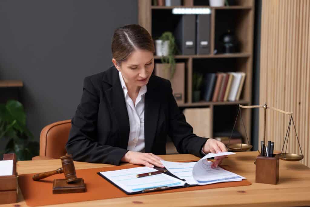 Professional Woman Attorney Reviewing Legal Documents at Office Desk